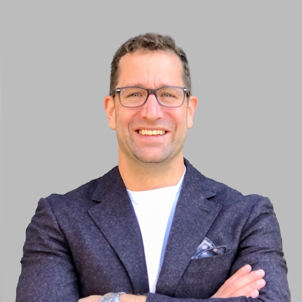 Nicholas from givens llp wearing glasses and a blue jacket smiling